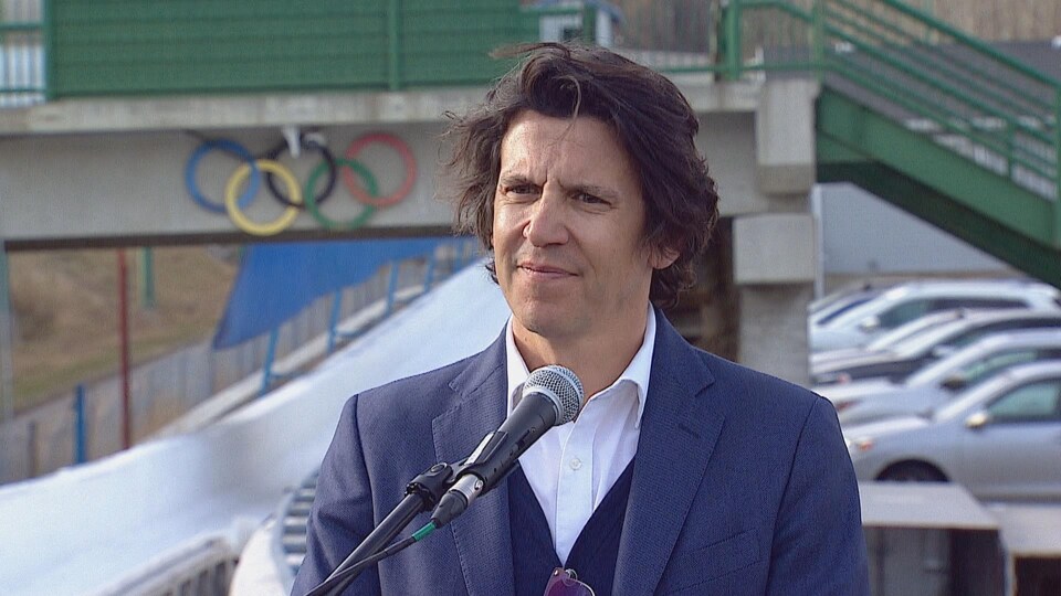 Christophe Dubi, le directeur général des Jeux olympiques répond aux questions des journalistes devant la piste de bobsleigh de Calgary.