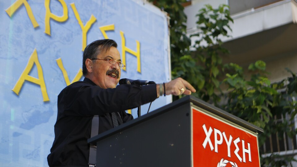Christos Pappas s'exprimant à un pupitre.