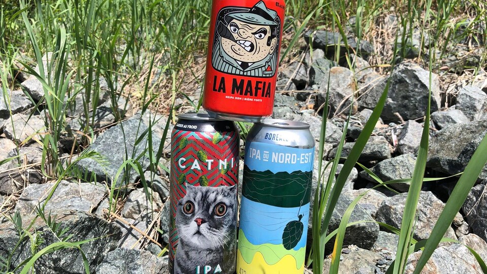 Trois canettes de bière empilées en pyramide.