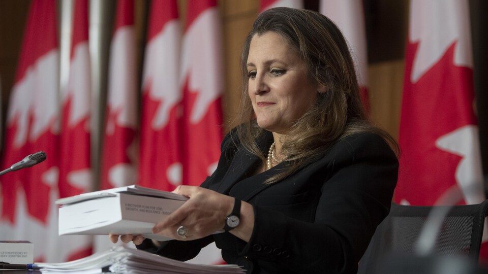 La ministre Chrystia Freeland en Chambre avec un exemplaire de son budget en main.