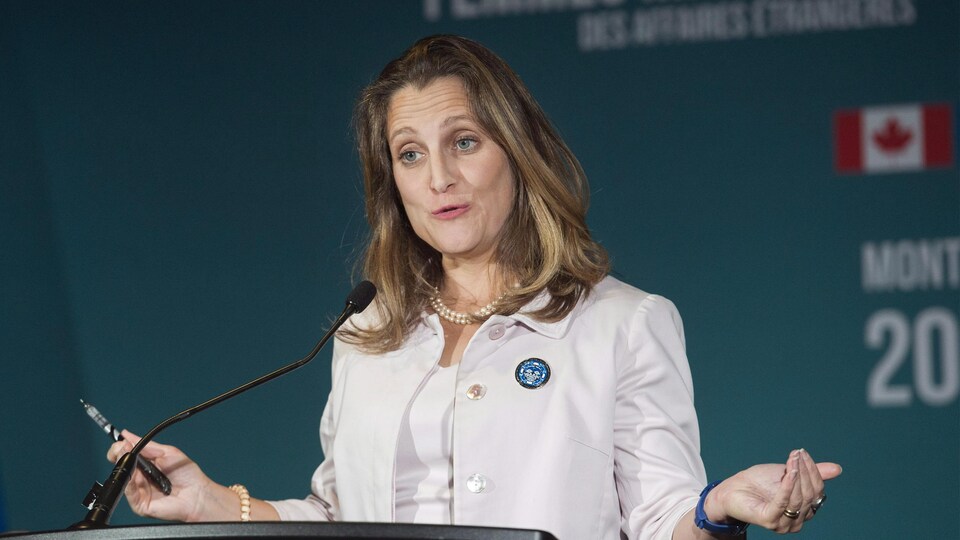 Une femme parle au micro lors d'un événement officiel.