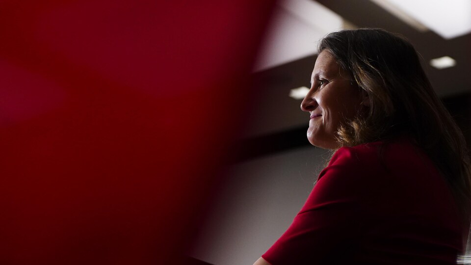 Chrystia Freeland fait un sourire en s'adressant à des journalistes.