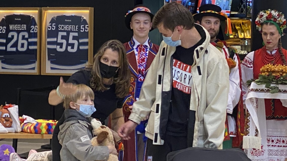 Chrystia Freeland with a man, a child and three volunteers in Winnipeg on May 23, 2022. 