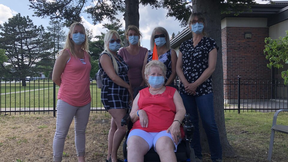 Six femmes portant le masque à l'extérieur.