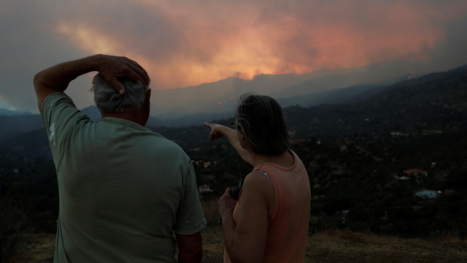 Des habitants observent le feu de forêt dans la région montagneuse de Larnaca.