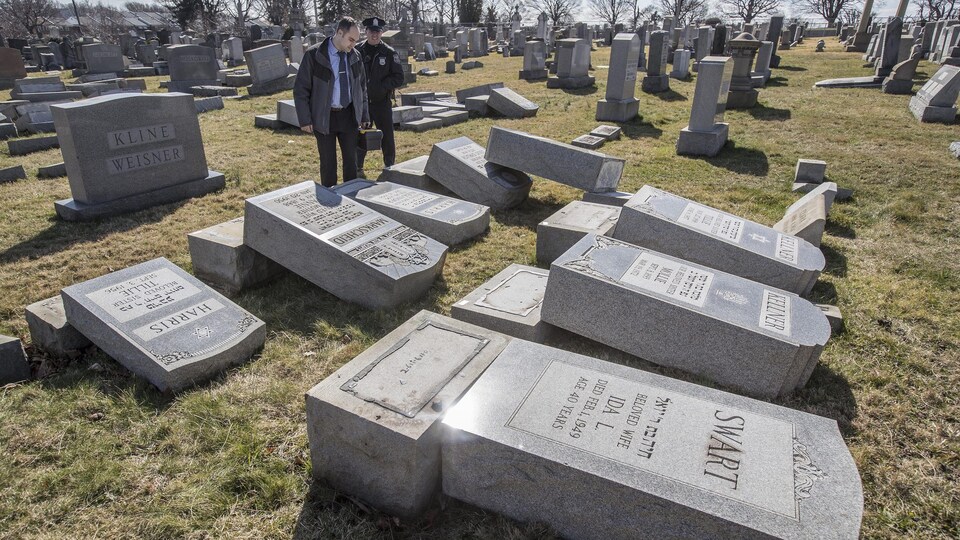 Des policiers observent les tombes qui ont été renversées dans un cimetière de Philadelphie.