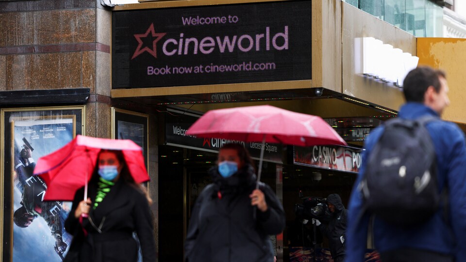 Des gens marchent devant une salle de cinéma de Cineworld.