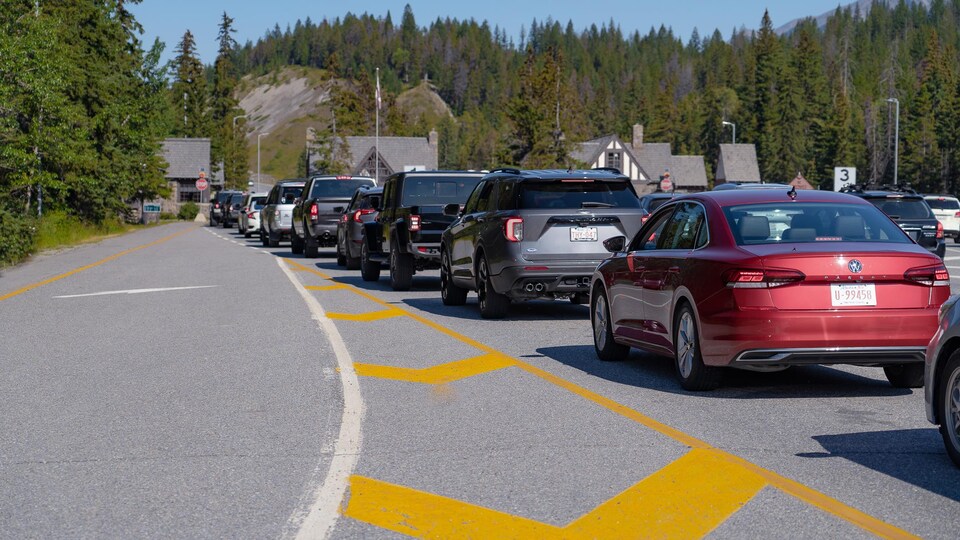 Une longue file d'automobiles attendent à l'entrée du parc national de Banff.