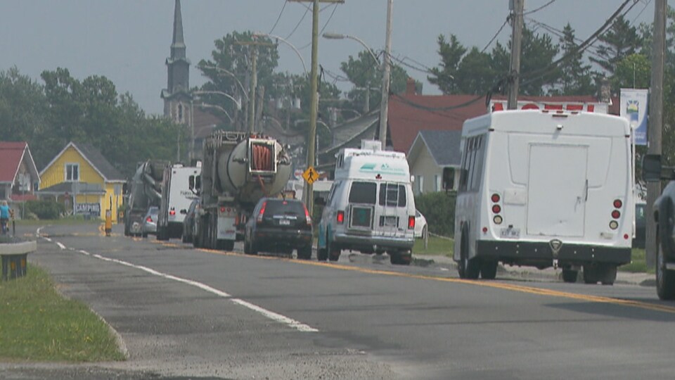 Beaucoup de véhicules circulent très lentement dans le village.