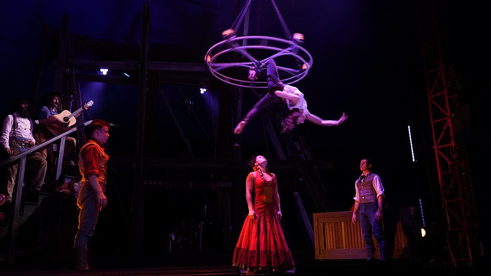 Des musiciens et des artistes acrobates sur la scène.