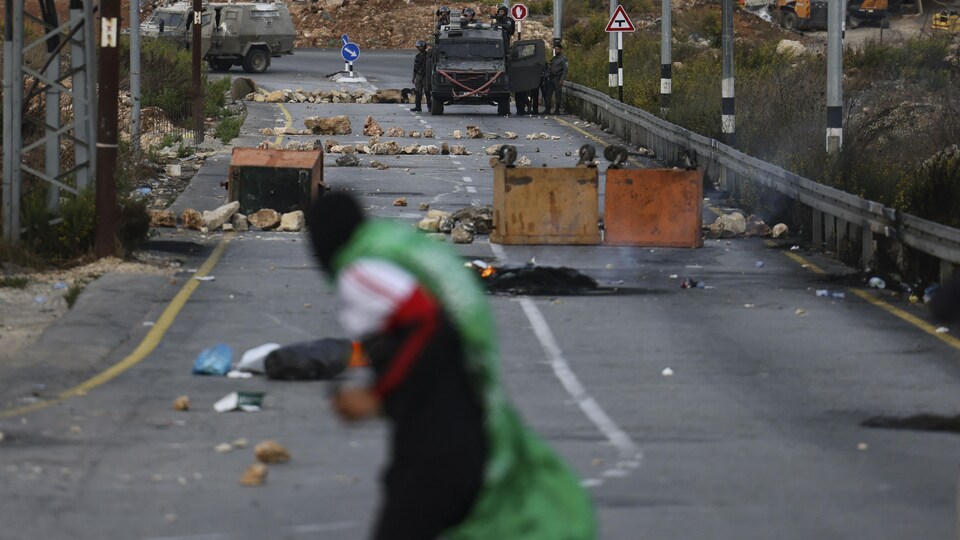 Un manifestant palestinien lance des pierres contre des soldats israéliens à Ramallah, en Cisjordanie