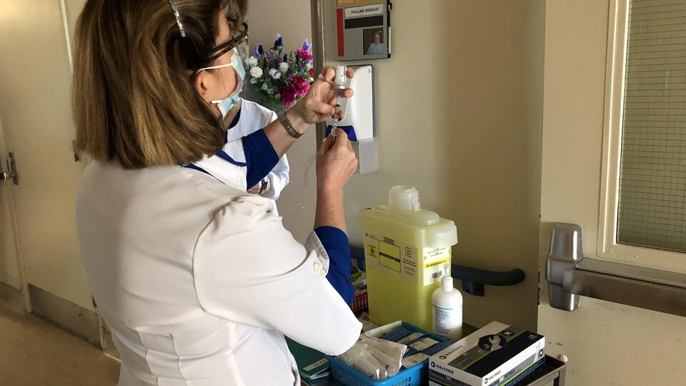 Une infirmière prend une injection.
