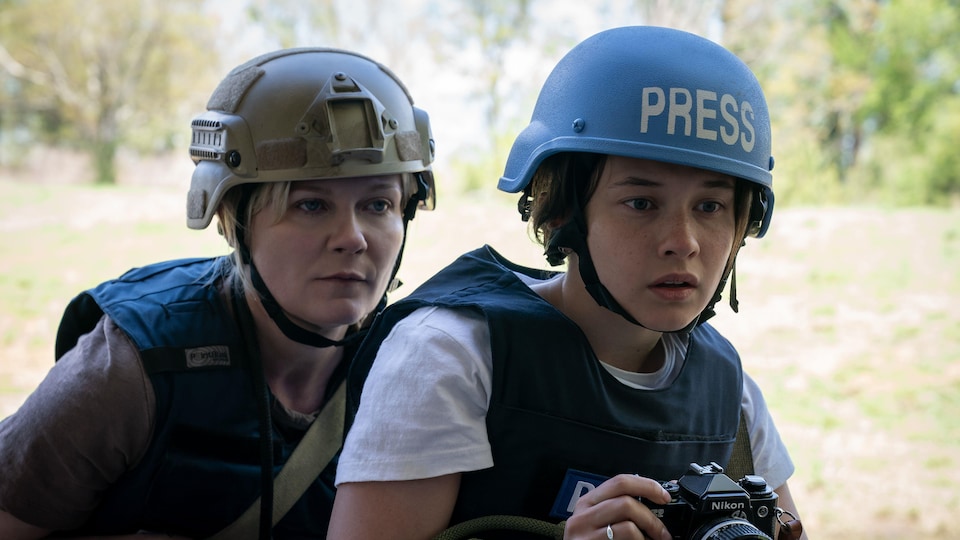 Deux femmes avec des casques de l'armée et un appareil photo.