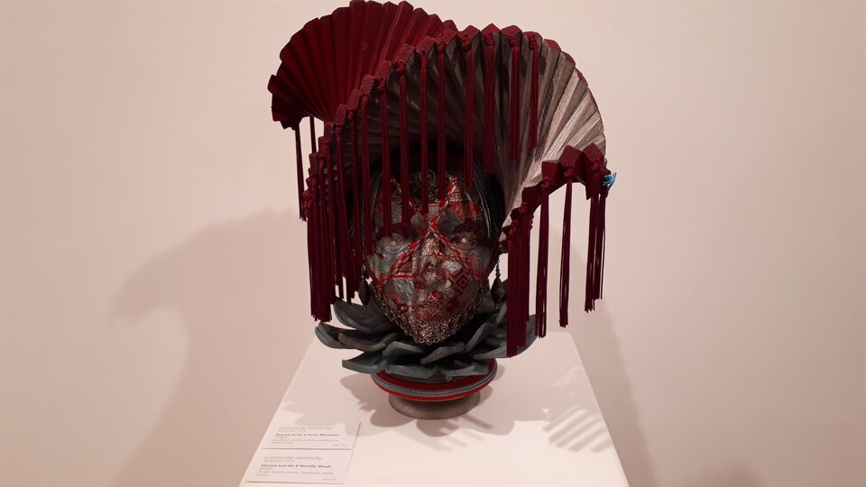 Une oeuvre artistique de Catherine Jamnicky représentant une sorte de masque avec une coiffe.
