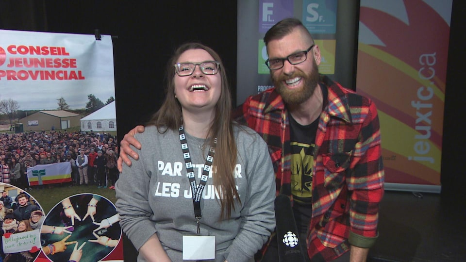 Deux jeunes ont le fou rire debout devant la lentille.