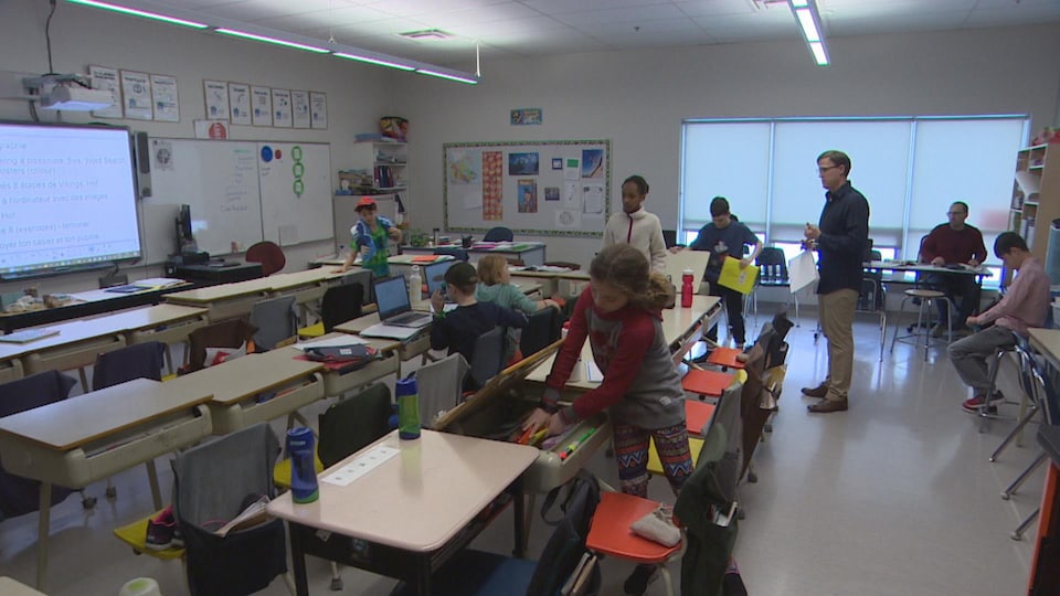 Salle de classe de l'école Taché avec des élèves et un professeur.