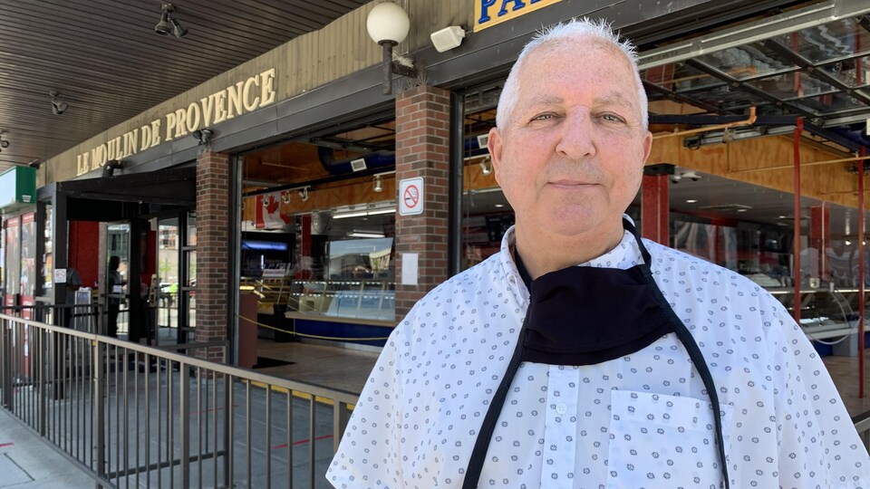 L'homme devant son restaurant.