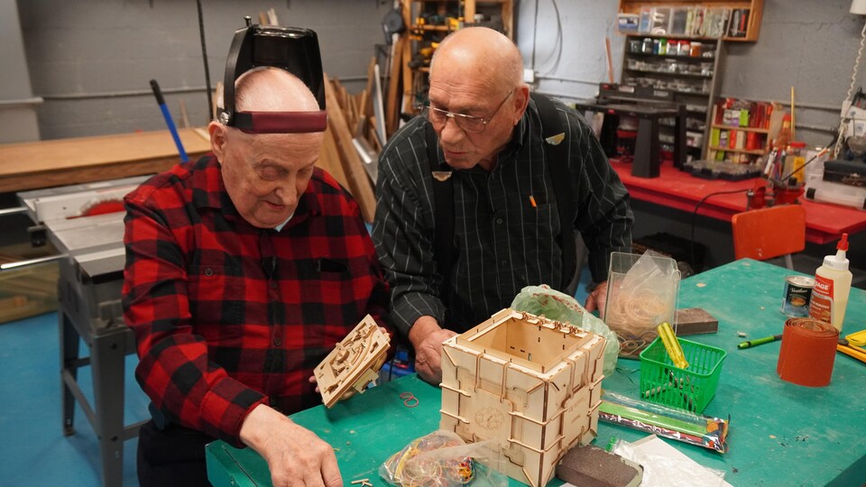 Dos personas construyen una caja de cabeza.