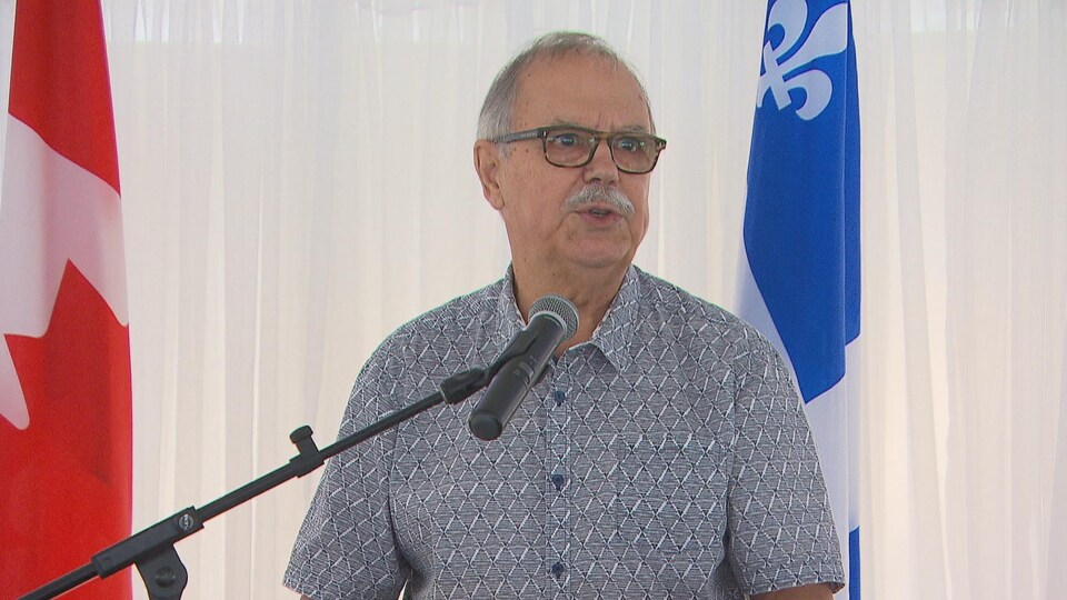 Claude Richard parle derrière un lutrin.
