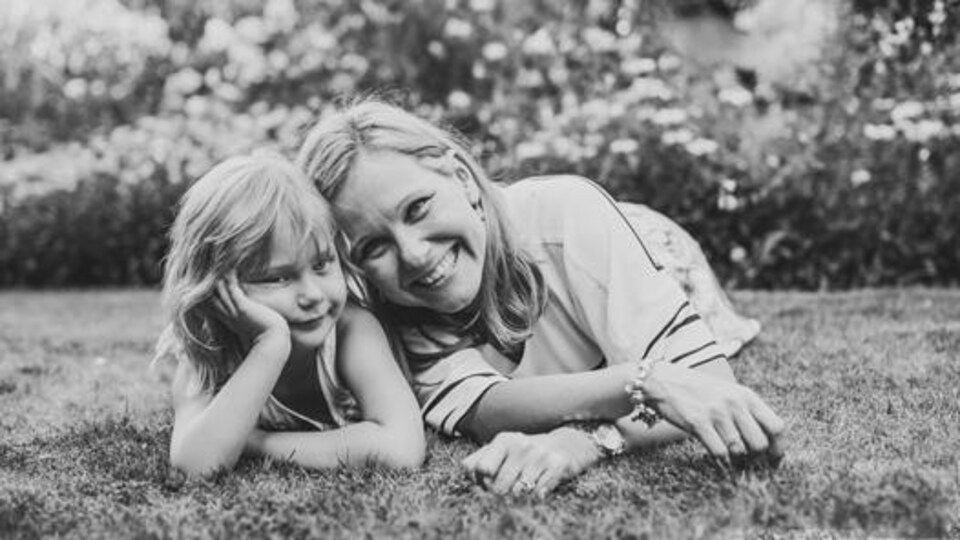 une femme et sa fille couchée dans l'herbe.