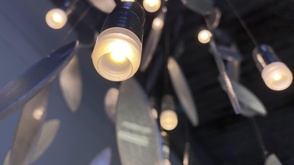 Suspension lumineuse de l'artiste Claudine Gévry faite de formes découpées dans de l'aluminium entre lesquelles sont placées des ampoules. 