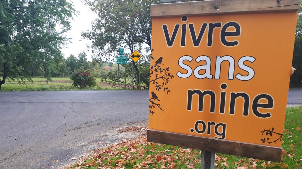 Une pancarte où il est écrit "vivre sans mine" sur un panneau d'arrêt.