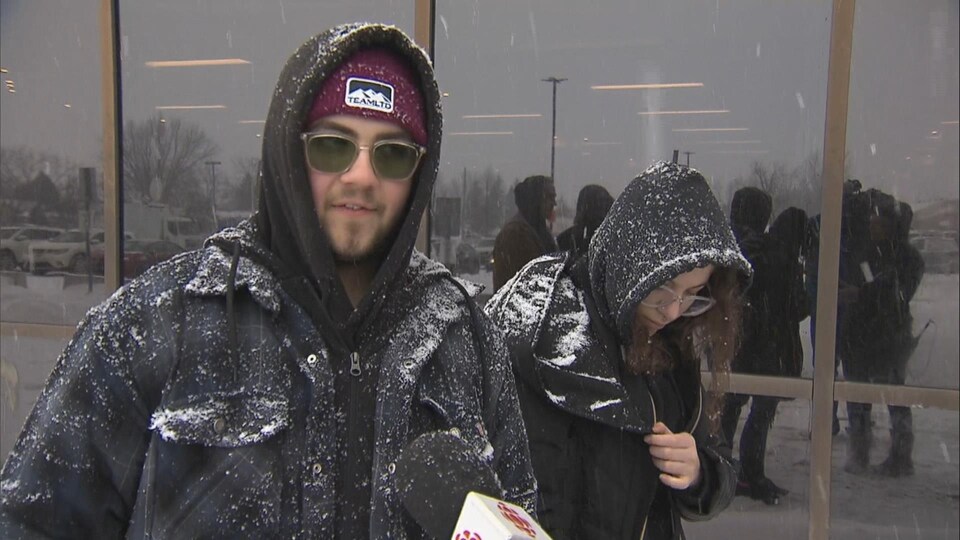 Un homme s'adresse aux journalistes sous la neige.