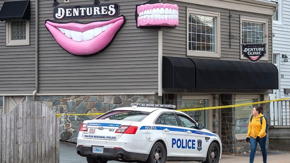 Devanture de La clinique de prothèses dentaires Atlantic Dentures gardée par un périmètre de sécurité et une voiture de police.