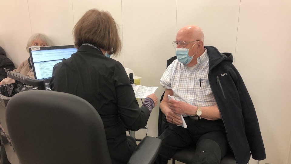 Un homme sur le point de recevoir sa première dose de vaccin contre la COVID-19