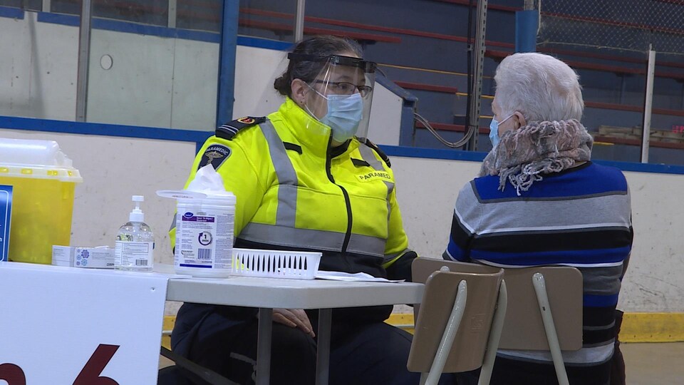 Deux personnes assises en face l'une de l'autre avec un masque.