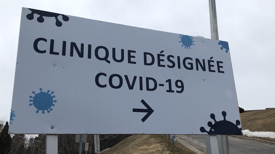 Une pancarte indique aux gens la direction à prendre pour se rendre à la clinique de dépistage du coronavirus de Chicoutimi.