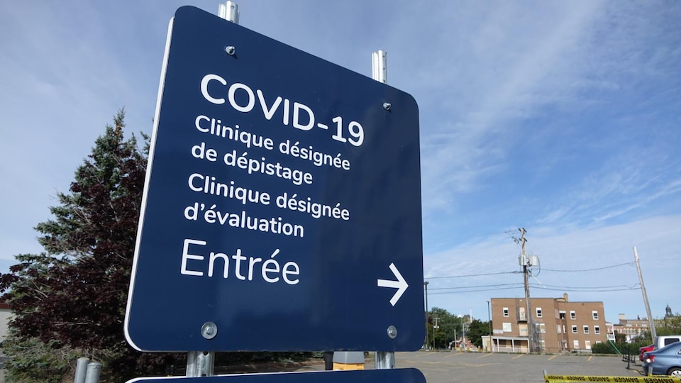 Une enseigne désigne l'entrée d'une clinique de dépistage à la COVID-19.
