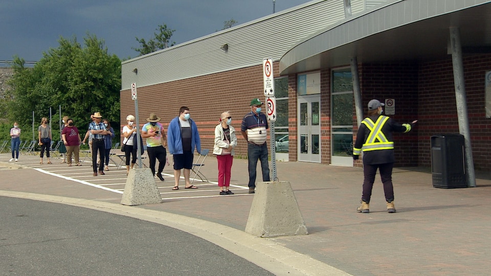Plusieurs personnes attendent en file devant le centre Countryside de Sudbury pour recevoir un vaccin.