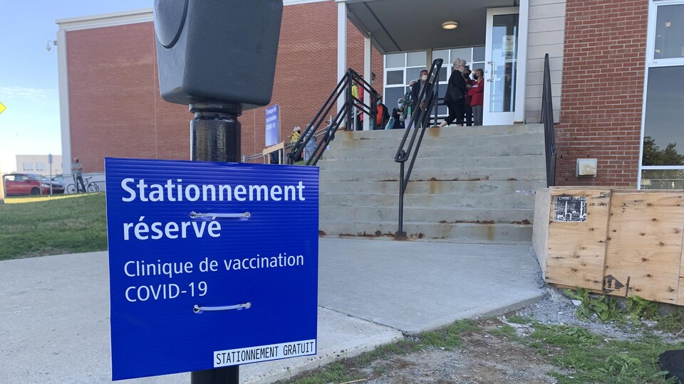 Plusieurs personnes attendaient tôt ce matin devant la clinique de vaccination contre la COVID-19 à Rouyn-Noranda. Des places de stationnement sont aussi réservées.