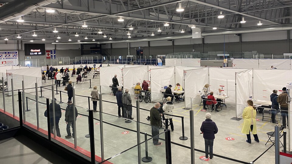 Des gens attendent pour recevoir un vaccin à la clinique de vaccination de Nicolet.