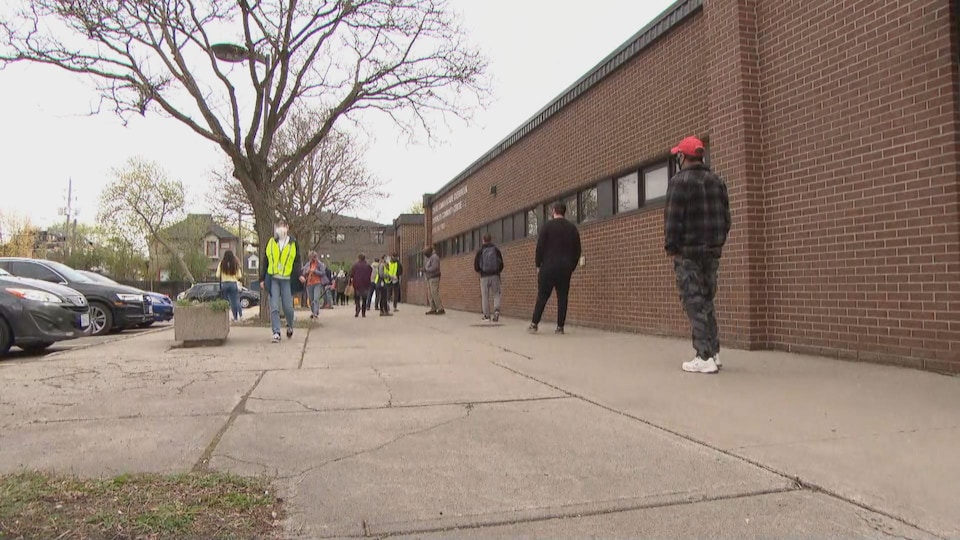 Des gens font la file, à deux mètres, devant le centre communautaire d'Overbrook.