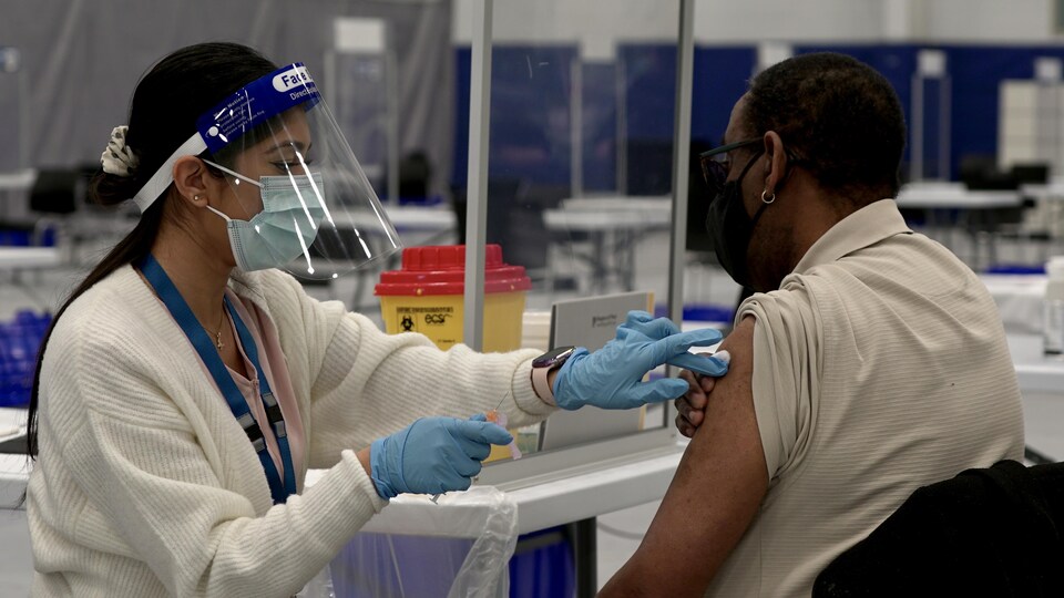 Un homme se fait vacciner contre la COVID-19.