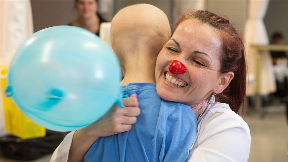 Josée Gagnon, de la Fondation Dr Clown, réconforte un garçon en attente de traitement.
