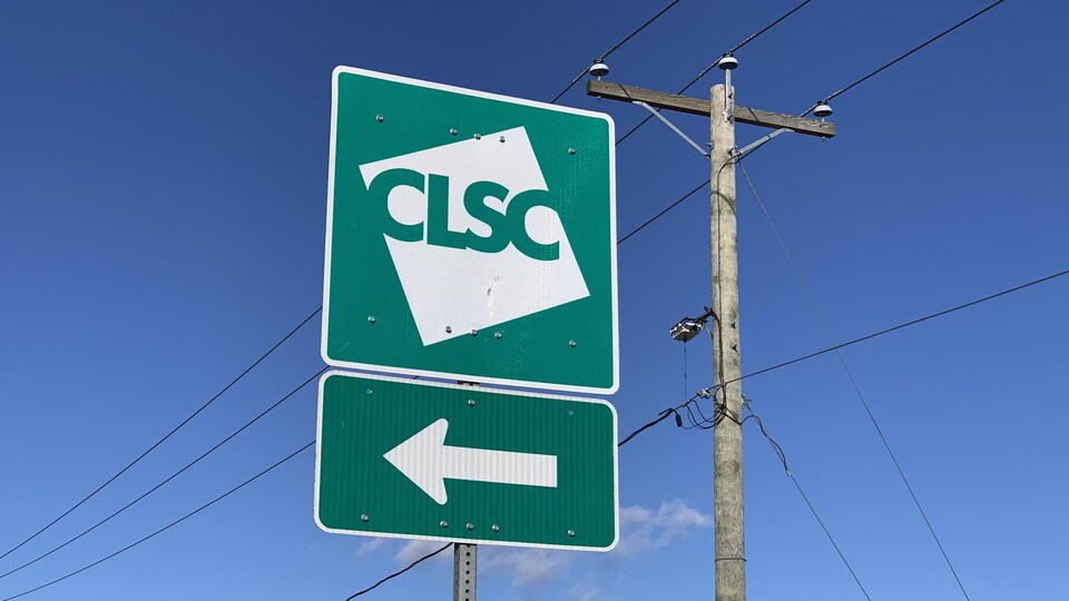 L'affiche d'un CLSC plantée près d'une route indique la direction à prendre pour se rendre à l'établissement.