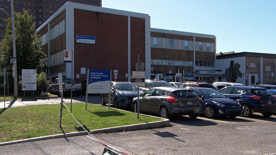 Des véhicules sont stationnés devant un édifice.