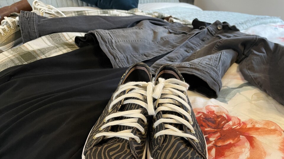 Des vêtements étalés sur un lit.