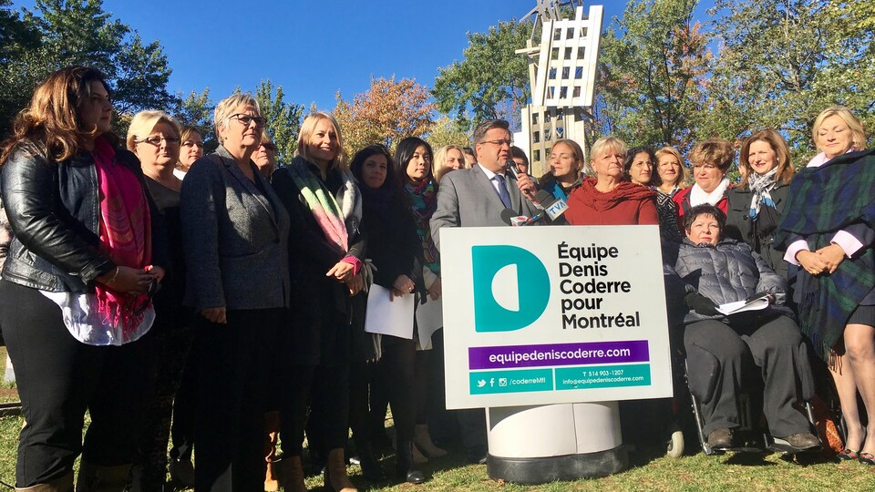 Le maire sortant de Montréal, Denis Coderre, entouré de plusieurs candidates de son équipe, le jeudi 12 octobre 2017, au parc Émilie-Gamelin.