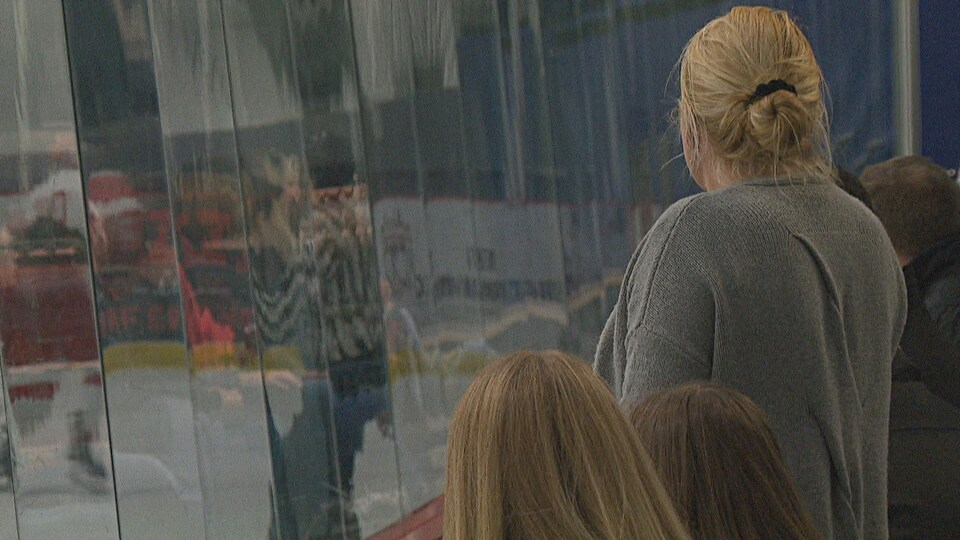 Des parents regardent une partie de hockey.