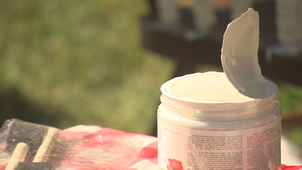 Un pot de peinture blanche sur une table.