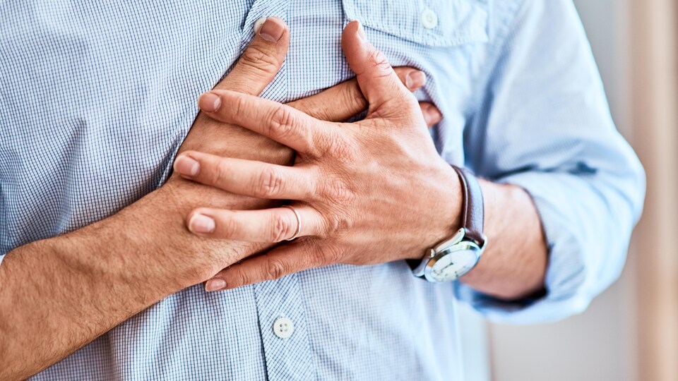 Un homme touche sa poitrine à l'endroit du coeur.