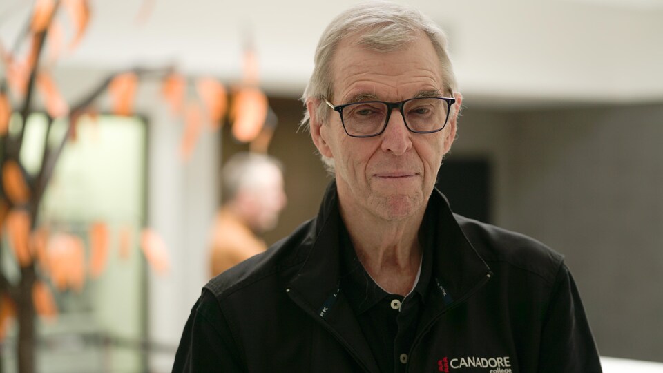 Colin Vickers porte une chemise noire