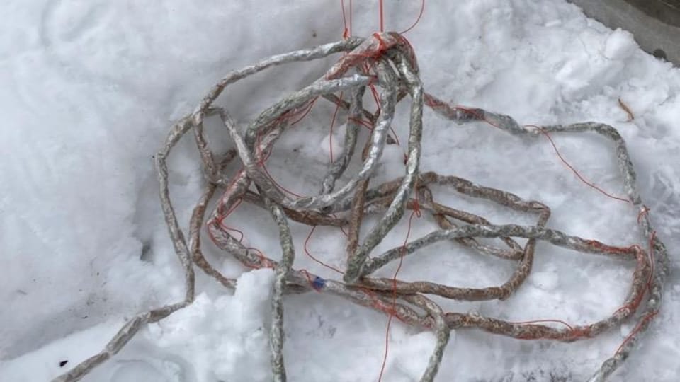 Paquet en serpentin contenant du cannabis, déposé dans la neige.