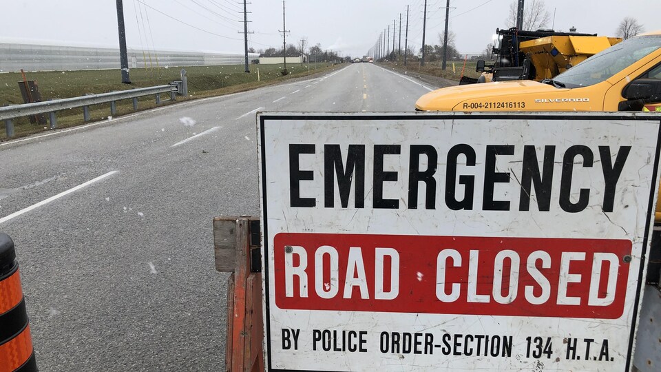 Un panneau de la police indique que la route est fermée.