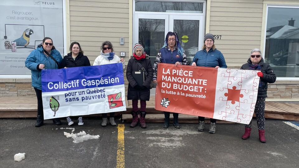 Des membres du collectif qui tiennent des banderoles.
