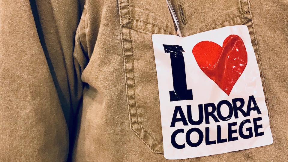 «J'aime le collège Aurora » est écrit en anglais sur un autocollant apposé sur la poche avant d'un manteau.